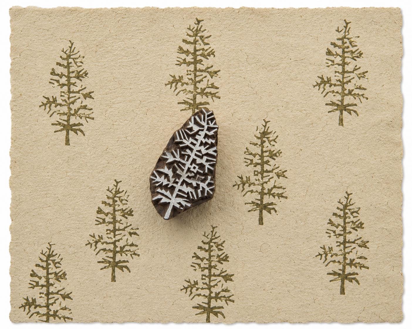 Evergreen tree printing block with repeated tree impressions on handmade paper