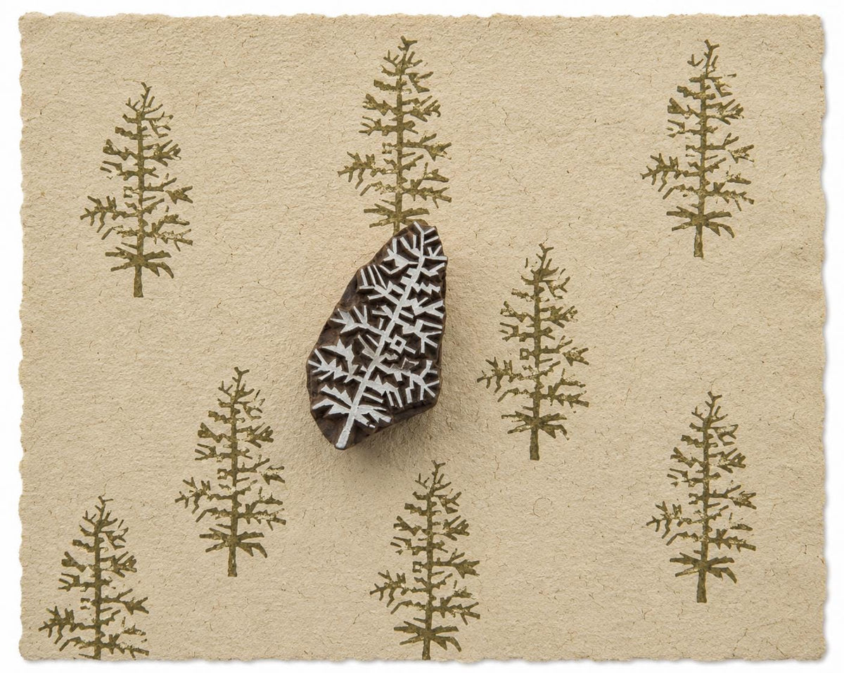 Evergreen tree printing block with repeated tree impressions on handmade paper