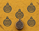 Hand carved festive Christmas ornament wooden printing block surrounded by navy blue ornament prints on textured mustard yellow handmade paper