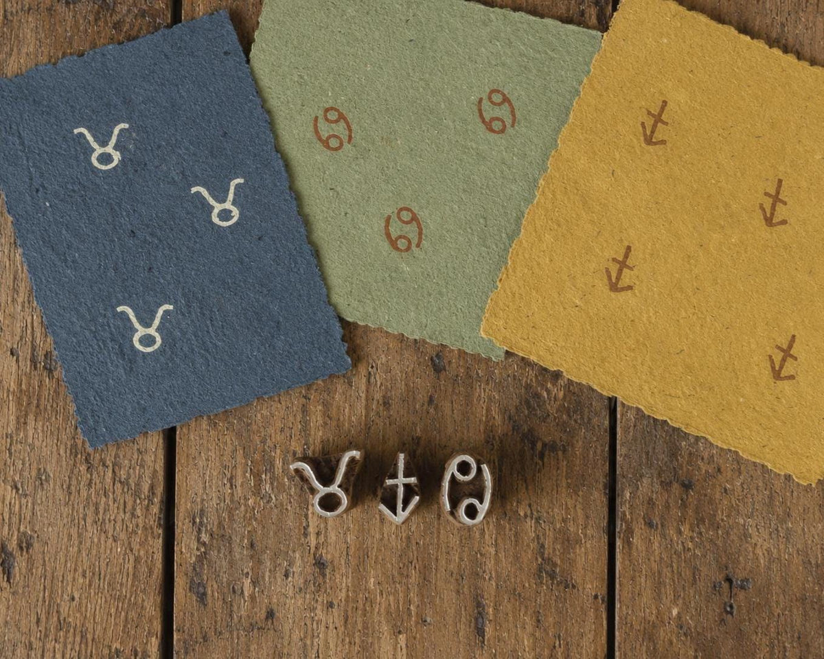 Tiny wooden zodiac printing block set featuring Taurus, Cancer and Sagittarius symbols