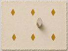 Small diamond printing block with repeated gold impressions on handmade paper