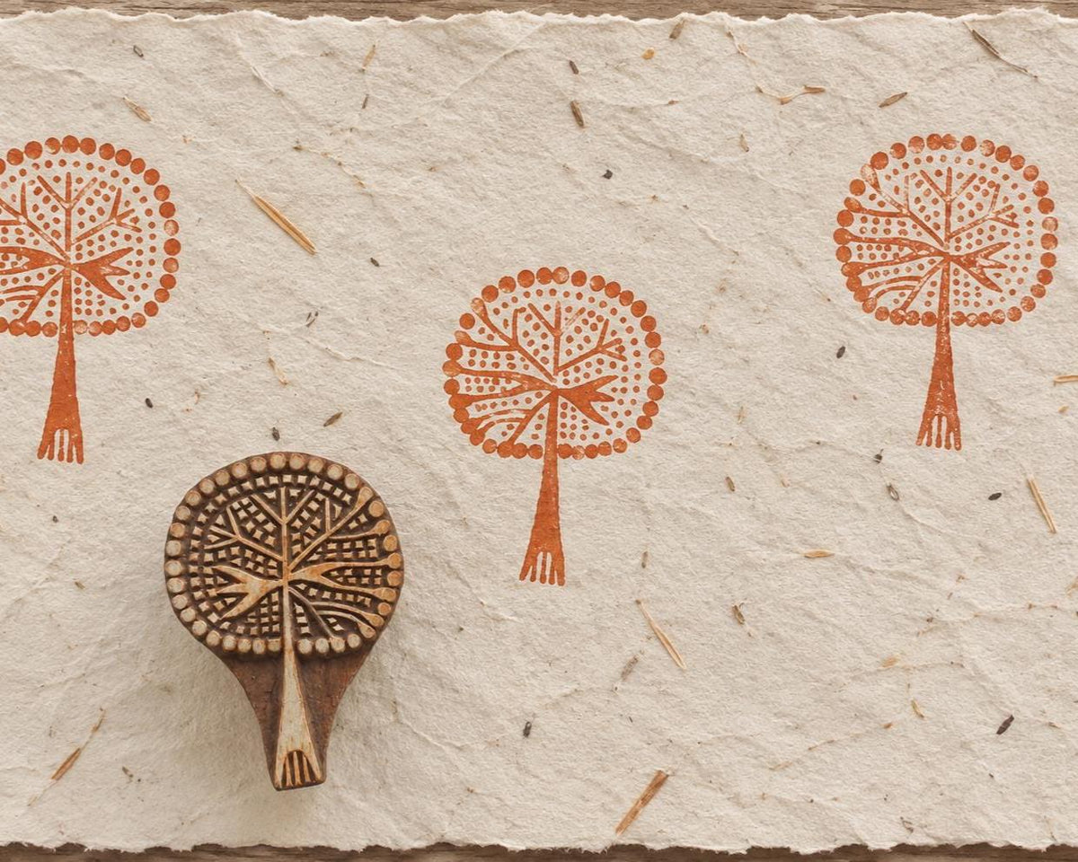 Crowned Tree hand carved wooden printing block with repeated terracotta impressions on handmade paper.