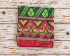 Folded vintage Indian silk sari piece in green with red yellow and burgundy geometric floral pattern