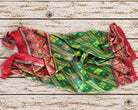 Vintage green silk sari piece loosely draped to show the flowing fabric and colourful geometric floral design