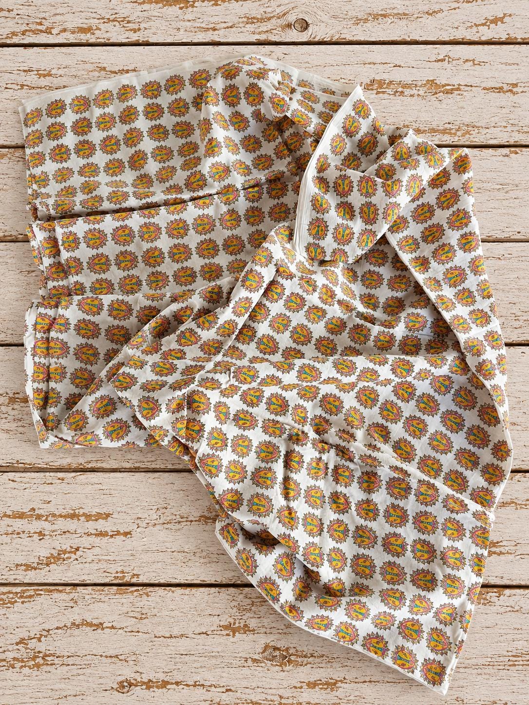Soft mulmul cotton fabric with colourful folk lion print shown in a drape