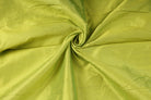 Draped chartreuse faux silk dupioni fabric showing its texture, folds and subtle sheen