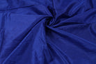 Midnight Sapphire faux dupioni fabric draped in flowing folds, showing the deep sapphire blue colour and textured faux silk surface.