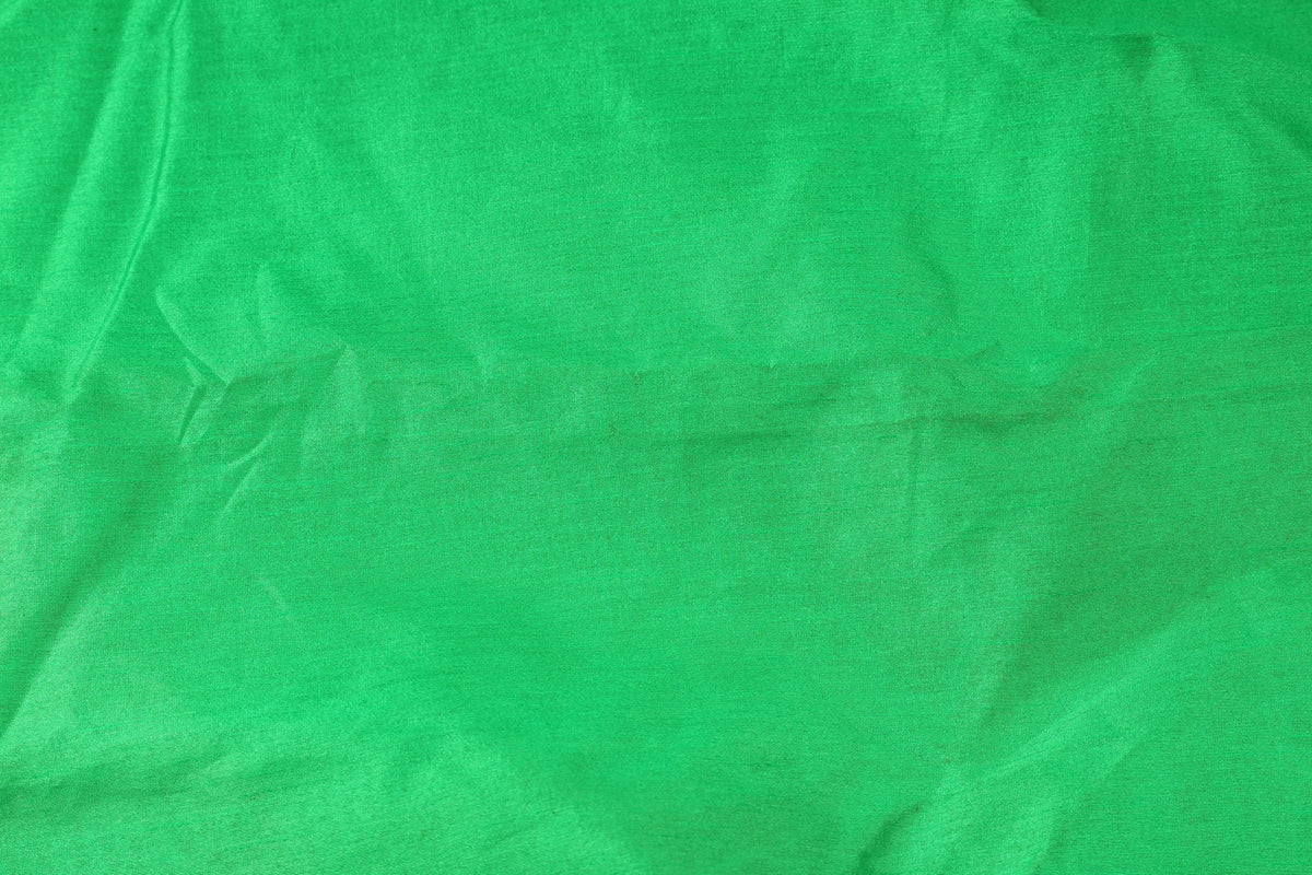 Bright parrot green faux silk fabric draped in soft flowing folds