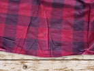 Close-up of raspberry pink and plum purple plaid silk showing the weave, colour variation and vintage character