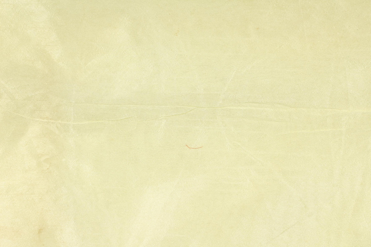 Close-up of pale vanilla cream faux dupioni fabric with a lightly textured surface and silk-like appearance.