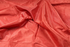 Close-up of vermilion faux dupioni fabric with a shantung-style slubbed finish