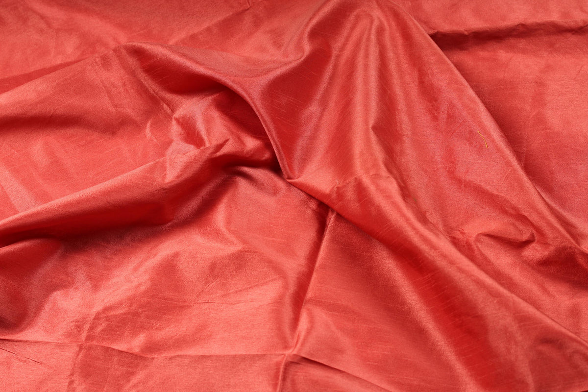 Close-up of vermilion faux dupioni fabric with a shantung-style slubbed finish