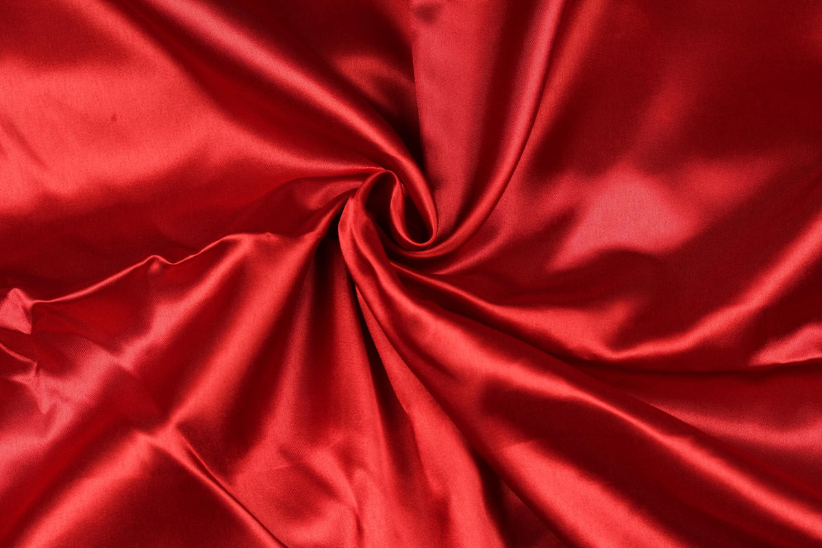 Deep crimson faux silk satin fabric showing its smooth silky surface and rich lustrous red colour.