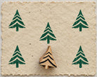 Wooden Christmas printing block featuring a stylized evergreen tree with layered branches, shown with repeated green prints.