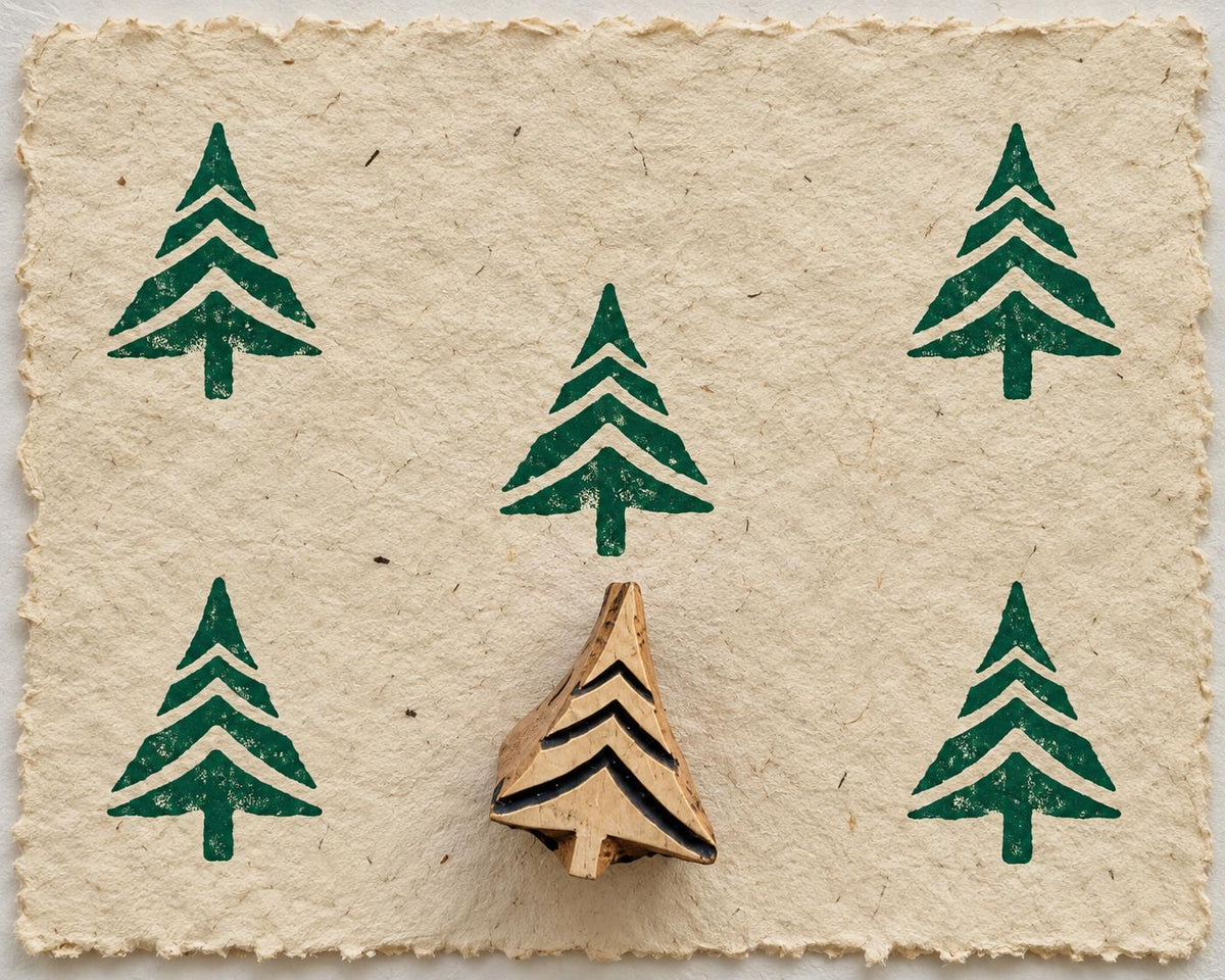 Wooden Christmas printing block featuring a stylized evergreen tree with layered branches, shown with repeated green prints.