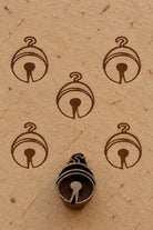 Wooden Christmas printing block featuring a simple round hanging ornament design, shown with repeated brown prints.