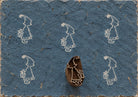 Wooden Christmas printing block featuring a little girl carrying a wrapped Christmas gift, shown with repeated white prints.