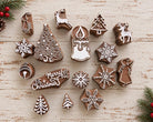 Set of 16 wooden Christmas printing blocks featuring trees, snowflakes, reindeer, candle, bell, angel and holiday motifs.