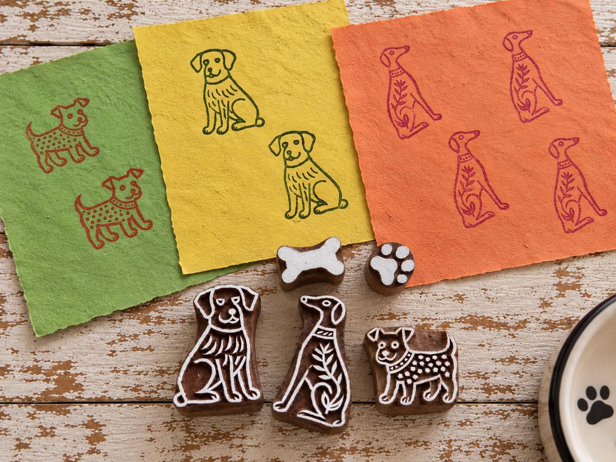 Set of five hand-carved wooden dog printing blocks including three dog designs, a bone and a paw print