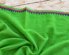 close up of bright green sari fabric showing colourful pink and blue woven edging