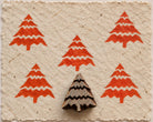 Zigzag Christmas Tree hand carved wooden printing block with repeated red Christmas tree impressions on handmade paper.