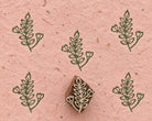 Heartbud Sprig 3cm hand carved wooden printing block with repeated green botanical impressions on pink handmade paper.