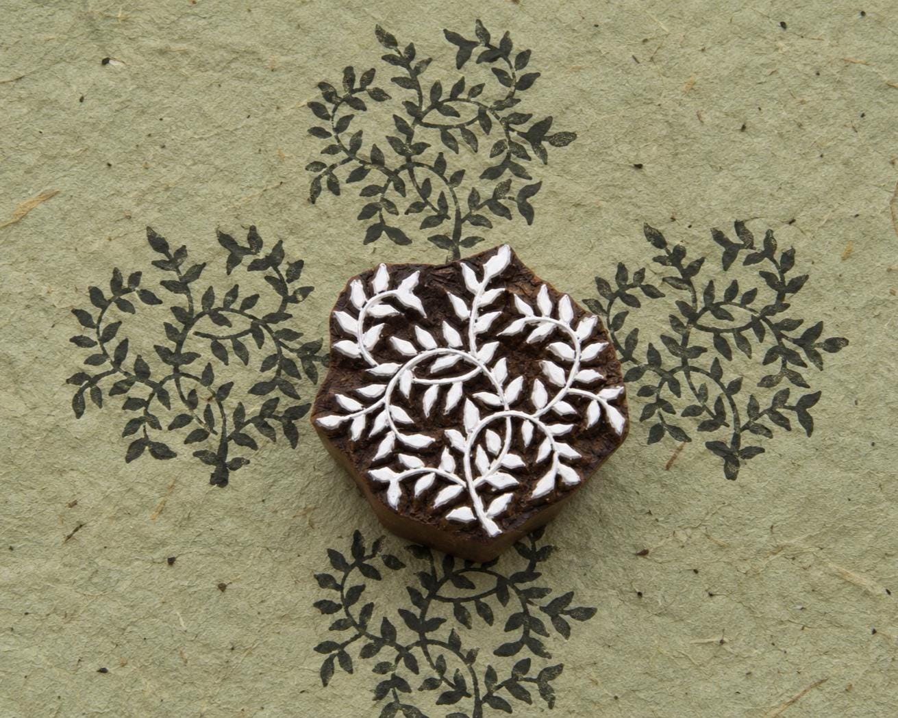 Fern Bloom hand carved wooden printing block with repeated fern-inspired botanical impressions on textured handmade paper.