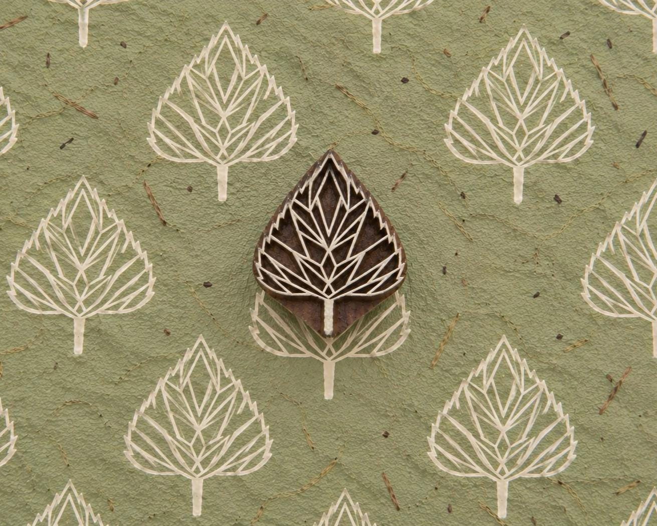 Folk Arrow Leaf hand carved wooden printing block with repeated leaf impressions on handmade green paper.
