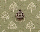 Folk Arrow Leaf hand carved wooden printing block with repeated leaf impressions on handmade green paper.