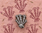 Leaf Burst hand carved wooden printing block with repeated botanical impressions on handmade pink paper.