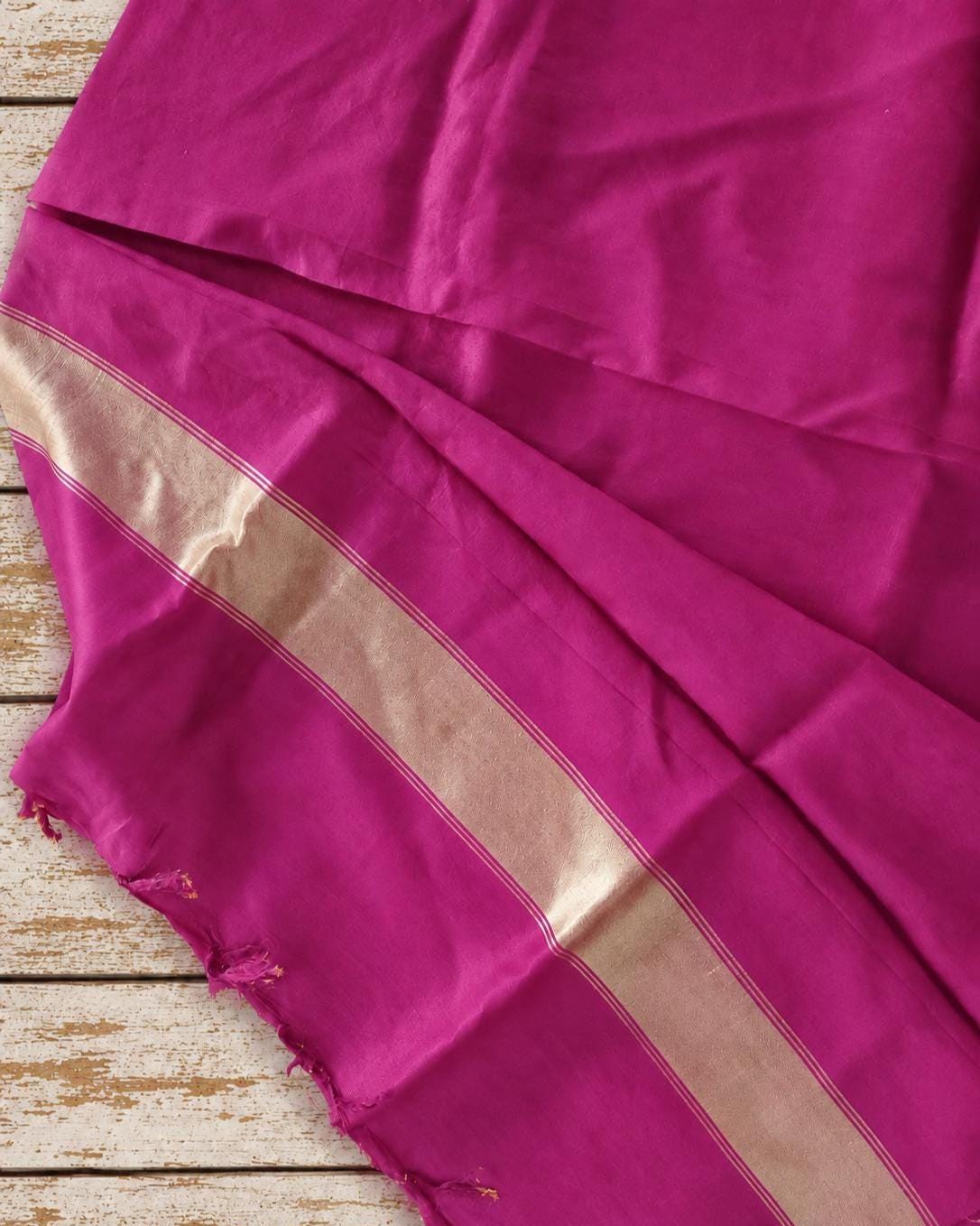 Magenta pink silk sari fabric with a wide woven metallic gold border