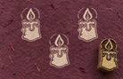 Wooden Christmas printing block featuring a decorative candle with flame and dripping wax, shown with repeated cream prints.