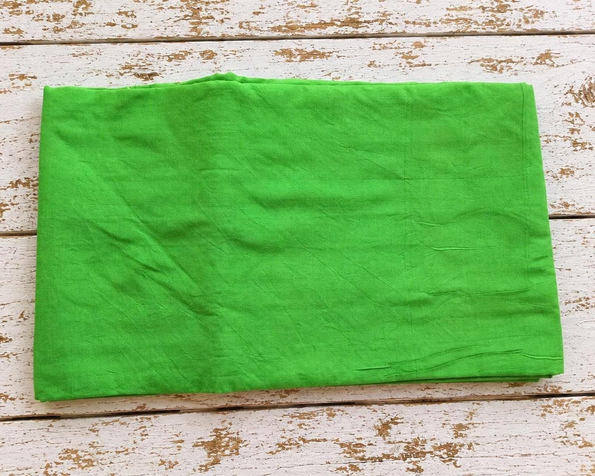 bright green vintage sari fabric folded to show the approximate 1 metre width