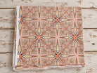 Folded peach mulmul cotton fabric with Vintage Starburst block print