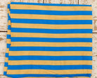 Close view of blue and beige 1.5 inch stripes on lightweight hand screen printed cotton fabric on flatlay table