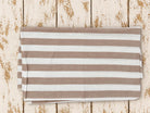Folded taupe and white striped lightweight cotton fabric showing the stripe pattern