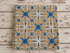 Folk Bloom hand block printed cotton fabric folded on a rustic wooden surface