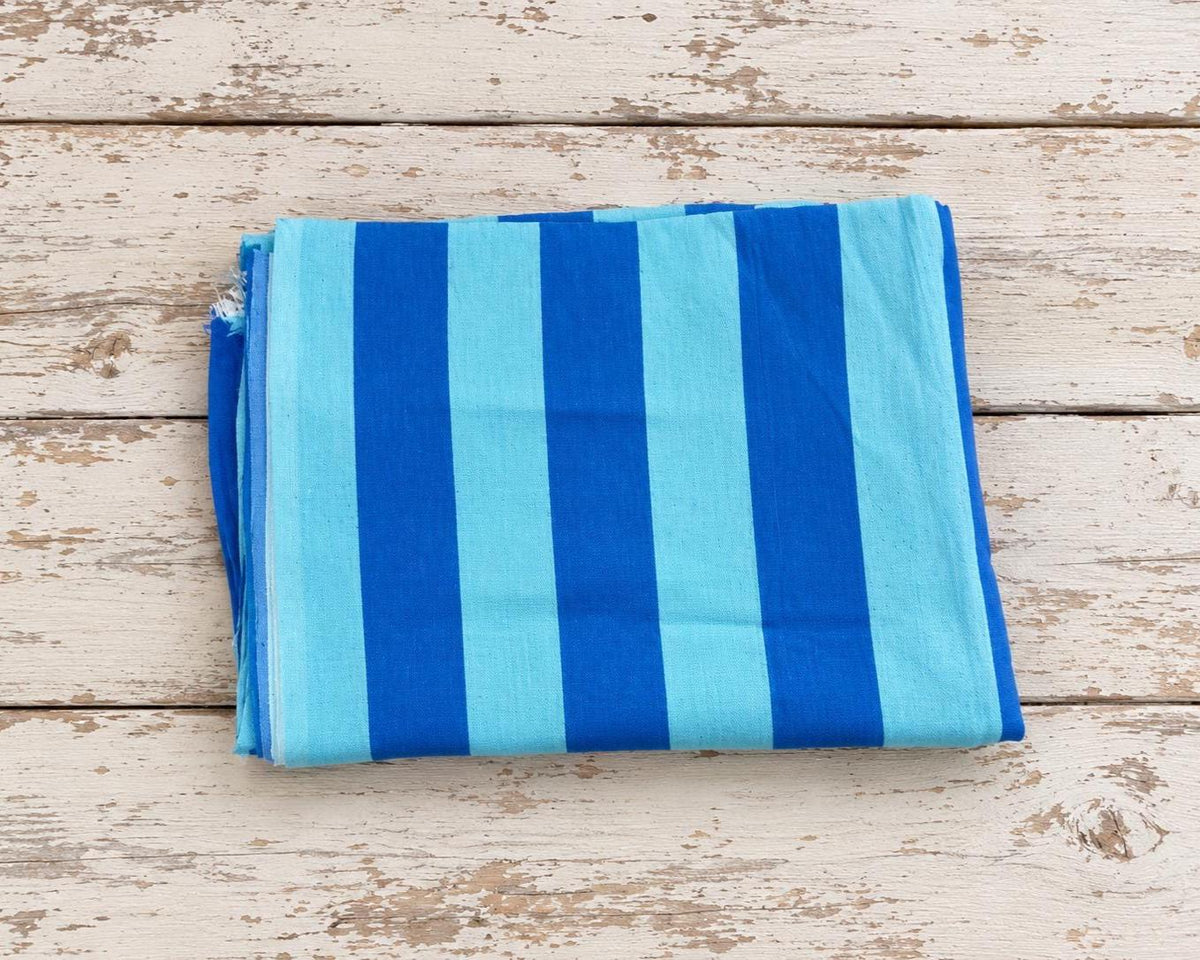 Folded Azure Tide cotton fabric featuring alternating bright blue and light blue stripes.