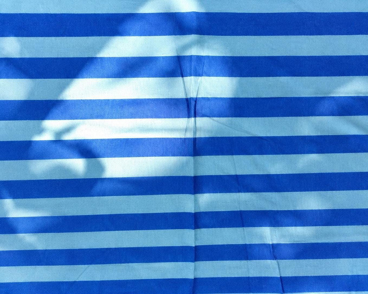 Close-up of the woven texture and contrasting blue bands of Azure Tide fabric.