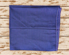 Folded vintage sari fabric in deep blue-purple with fine magenta vertical stripes and a neatly stitched edge.