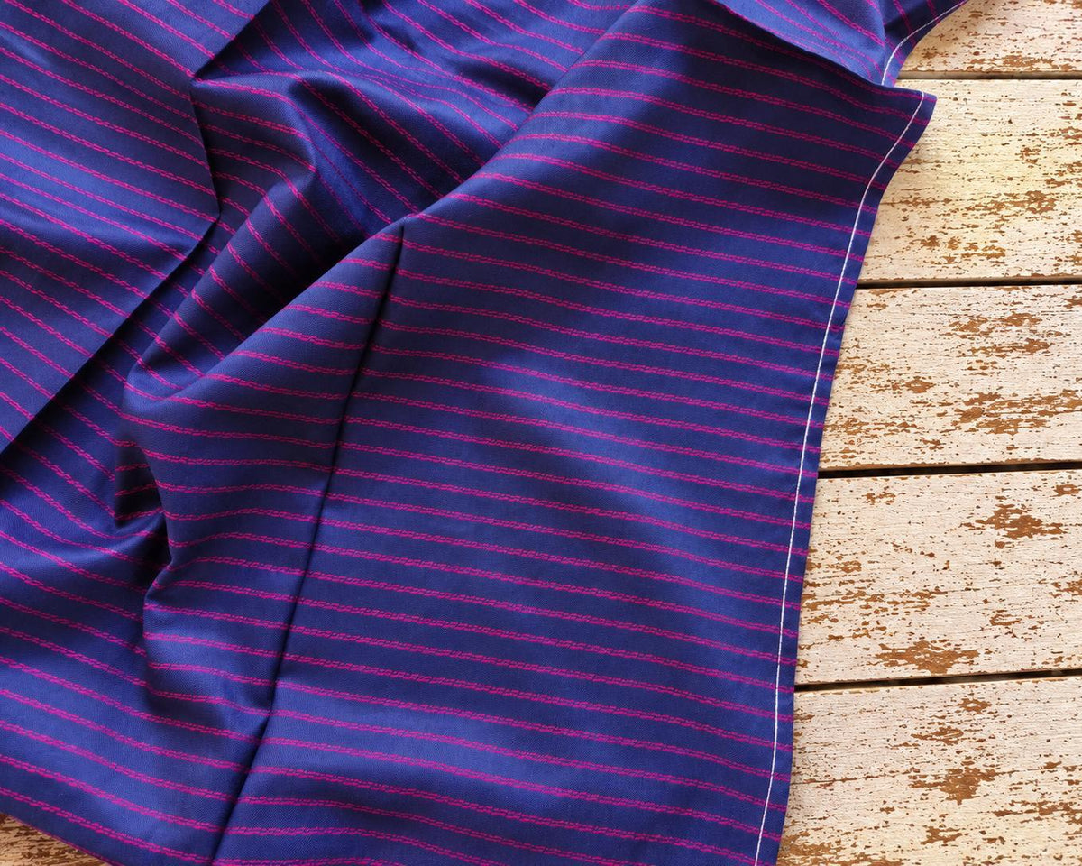 Blue-purple vintage sari fabric with narrow magenta stripes, draped to show the stripe pattern and finished edge.