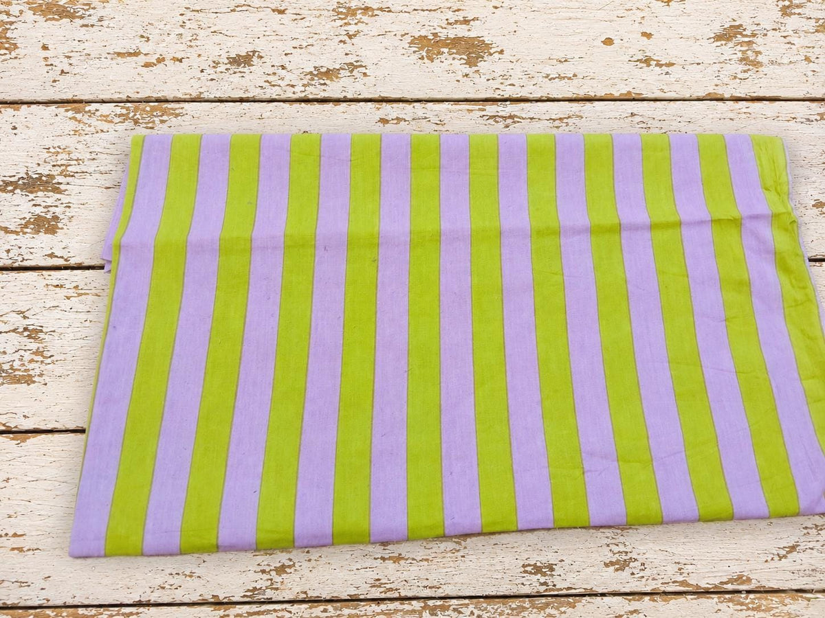 Folded lavender and lime green striped cotton fabric showing the full stripe pattern