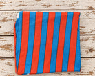 Draped red and blue striped lightweight cotton fabric showing its bold graphic pattern