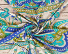 Close-up of vintage silk featuring turquoise, blue and olive paisley patterns on ivory.