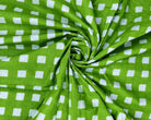 Close-up of vivid green fabric featuring a repeating white gingham check pattern.