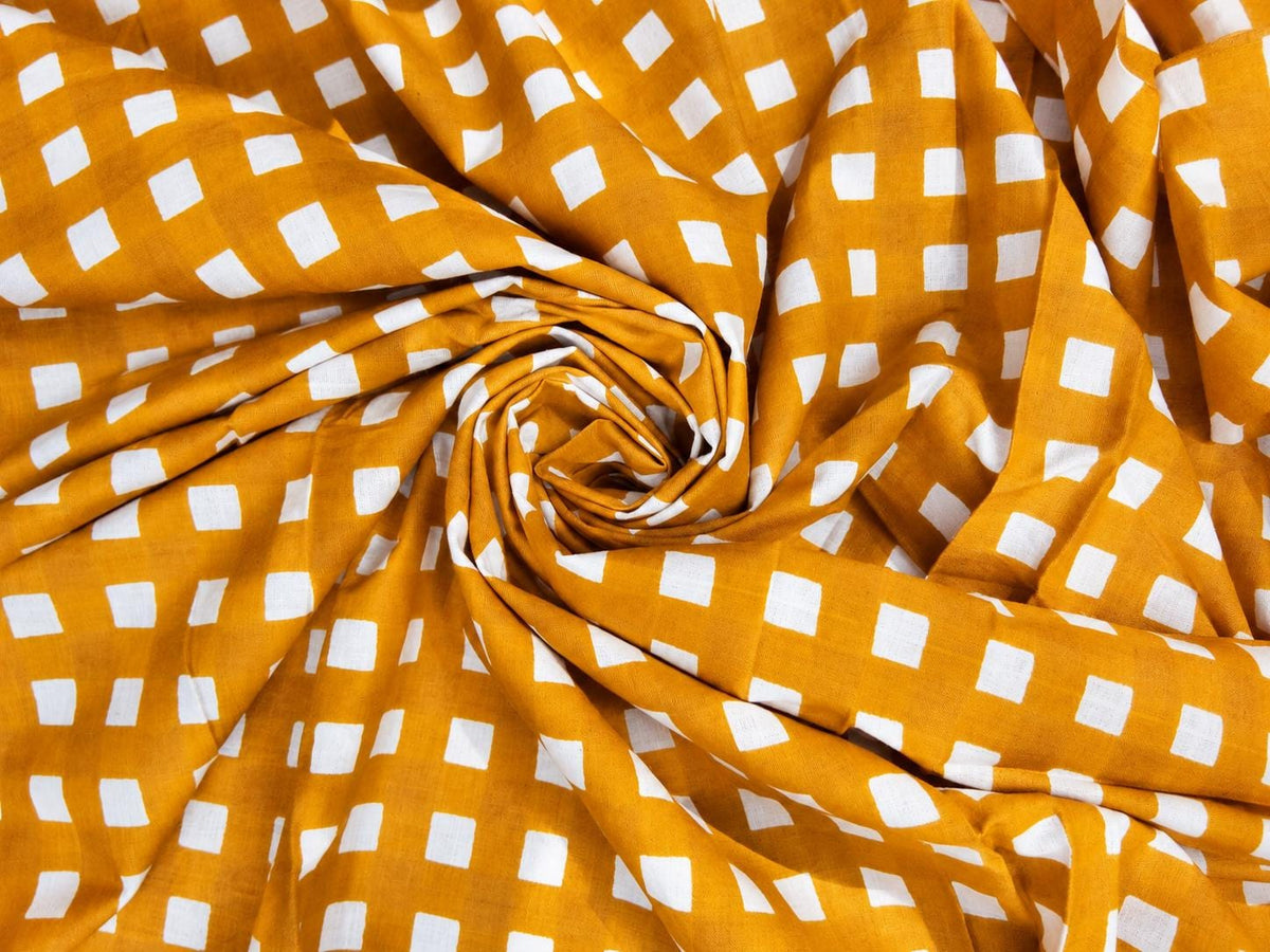 Close-up of golden mustard fabric showing its repeating white check pattern and texture.