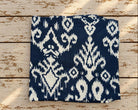 Folded navy blue and cream cotton fabric featuring a bold all-over ikat-inspired print.
