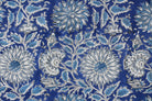 Close-up of Indigo Chrysanthemum Heritage cotton fabric showing chrysanthemum flowers, botanical leaves, and hand block printed details