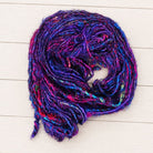 Coiled Jewel Tones recycled sari silk yarn displaying colour variation and textured sari silk fibres.