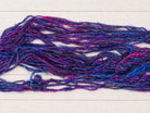 Close-up of Jewel Tones recycled sari silk yarn showing textured handspun fibres and vibrant jewel-tone colours.